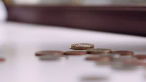 Einzelne-Britische-Pfundmünze-Dreht-Sich-Und-Fällt-In-Zeitlupe,-Während-Die-Anderen-Münzen-Flach-Liegen