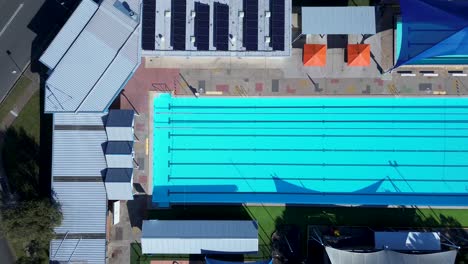 Landscape-view-of-empty-swimming-olympic-outdoor-pool-building-at-Swansea-leisure-centre-sport-fitness-community-street-Belmont-Newcastle-Australia-drone-aerial
