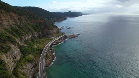 A-4K-Drone-video-following-a-white-camper-van-driving-along-the-Sea-Cliff-Bridge-in-New-South-Wales-Australia