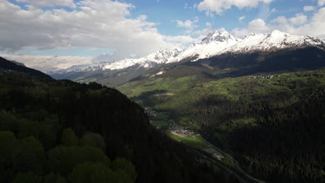 Vista-Aérea-Del-Valle-En-Obersaxen,-Graubünden,-Suiza,-Rodeado-Por-Picos-Nevados.