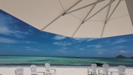 Weißer-Sonnenschirm-Und-Liegestühle-Am-Strand-Vor-Der-Karibik,-Insel-Madrisqui