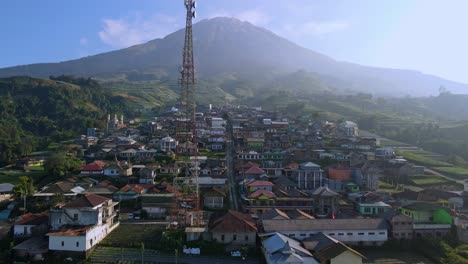 Aerial-establisher-small-village-on-the-foot-of-mountain-Sumbing,-Indonesia