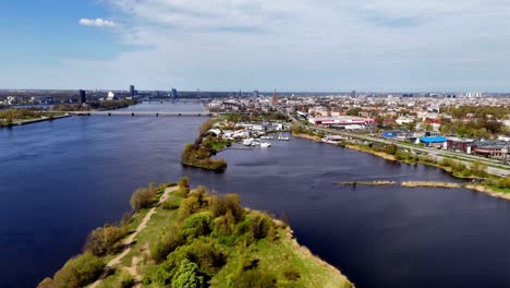Letonia,-Europa---El-Puente-De-La-Isla---Un-Puente-Que-Cruza-El-Río-Daugava-En-Riga---Drone-Volando-Hacia-Adelante