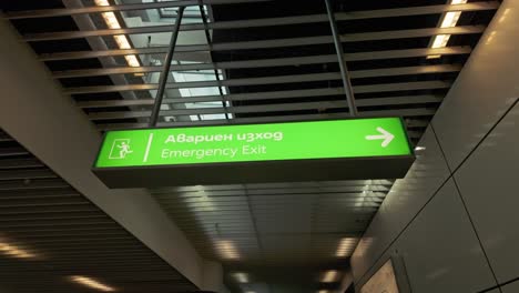 Emergency-exit-illuminated-bilingual-sign-display-at-Bulgarian-airport