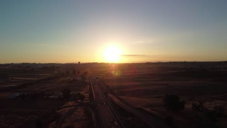 Sonnenaufgang-über-Der-Stadt-Pozoblanco-In-Córdoba,-Spanien-Mit-Bahngleisen,-Die-In-Den-Horizont-Führen