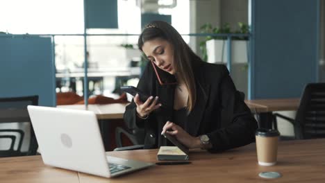 Una-Mujer-Bonita-Se-Sienta-Con-Determinación-En-La-Oficina,-Trabaja-En-Su-Computadora-Portátil-Y-Se-Esfuerza-Por-Afrontar-Una-Tarea-Desafiante