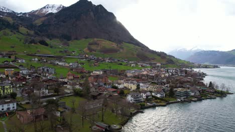 Aerial-View-of-Beckenried-Village-Under-Swiss-Alps-on-Coast-of-Lake-Lucerne,-Drone-Shot