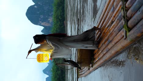Hanfu-Girl-holding-a-lantern-on-a-bamboo-raft,-Xingping,-China