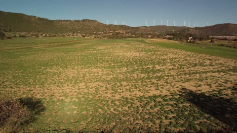 Windmills-spinning-on-a-sunny-day-over-green-fields-and-rolling-hills-in-Igualada,-Barcelona