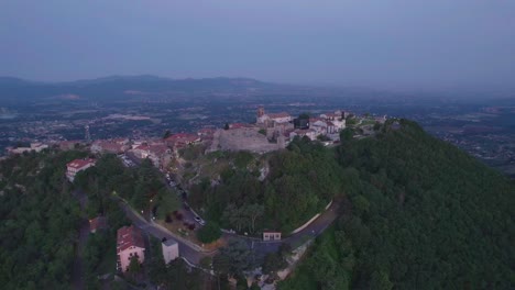 Small-mountain-top-village-aerial-orbit-at-dawn,-Italy