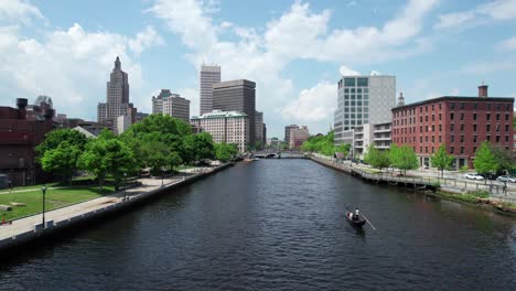 Drone-flight-follows-the-providence-river,-the-city-in-the-background