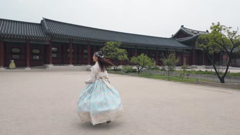 Ein-Fröhliches-Mädchen-In-Einem-Farbenfrohen-Hanbok,-Das-Aufgeregt-Zum-Majestätischen-Gyeongbokgung-Palast-Rennt