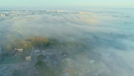 City-seen-above-covered-in-fog,-aerial-drone-view