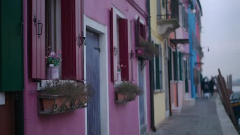 Colorful-buildings-along-Burano-Island's-canals,-vibrant-facades-reflect-on-water