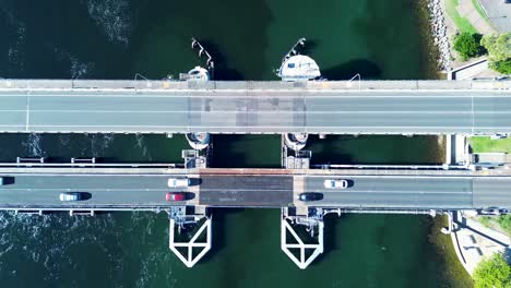 Landscape-pan-of-car-traffic-travelling-over-bridge-main-road-town-suburbs-of-Swansea-Belmont-Newcastle-Australia-drone-aerial-transport-tourism