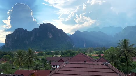 Timelapse-over-the-city-of-Vang-Vieng-in-Laos,-showing-clouds-moving-rapidly-over-the-magnificent-mountains