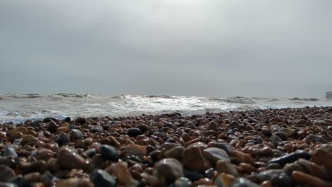 Low-Angle-View-of-Choppy-Sea-with-Sun-Reflecting-on-Ocean-on-Brighton-Beach,-UK