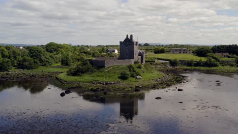 Aerial-orbit-of-tranquil-Dunguaire-Castle-beautifully-reflected-on-the-water