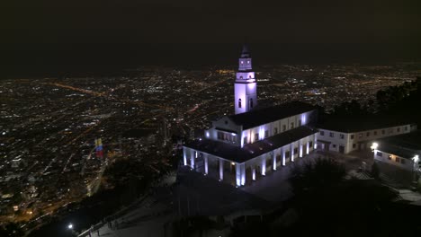 Drohnenaufnahme-Der-Monserrate-Kirche-Mit-Blick-Auf-Die-Stadt-Bogota,-Kolumbien-Bei-Nacht