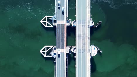 Querformatansicht-Von-Autos,-Die-Entlang-Der-Hauptstraße-Der-Autobahn-über-Den-Swansea-Channel-Inlet-River-Bridge-Wharf-Pier-Belmont-Australien-Fahren,-Transportdrohne-Aus-Der-Luft