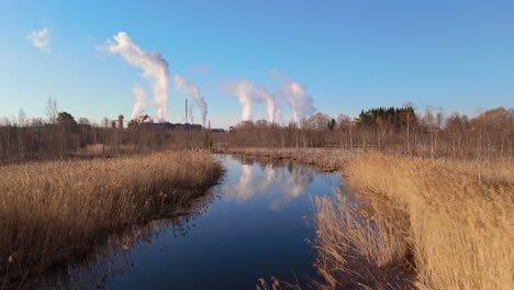 Gegenüberstellung-Des-Natürlichen-Flussökosystems-In-Der-Nähe-Einer-Fabrik,-Die-Giftige-Gase-Ausstößt