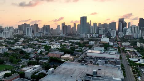 Niedrige-Luftaufnahme-über-Der-Nachbarschaft-In-Miami-Mit-Sonnenaufgang-Im-Hintergrund