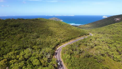 4K-drone-video-of-white-camper-van-driving-on-the-road-through-Wilsons-Promontory-in-Victoria,-Australia