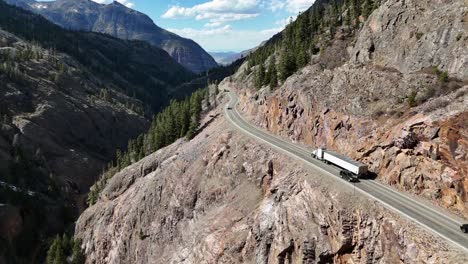 Semi-Truck-Driving-down-the-highway,-edge-of-the-mountain,-Colorado's-Million-Dollar-Highway
