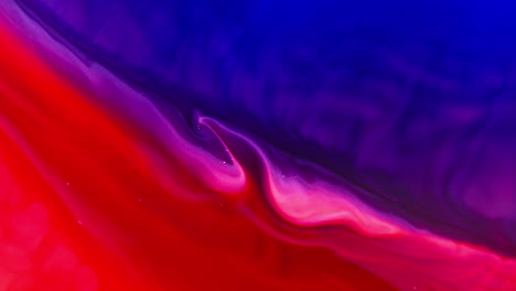Tinta-Roja-Y-Violeta-Vibrante-Arremolinándose-En-El-Agua-Creando-Patrones-Abstractos