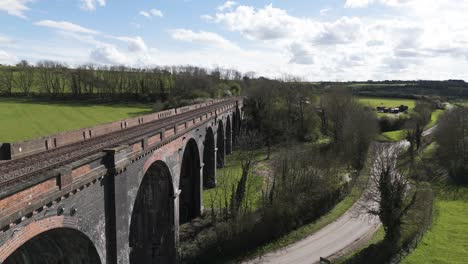 Close-slow-rising-drone-footage-of-Welland-Viaduct-Northamptonshire,-also-known-as-the-Harringworth-and-Seaton-Viaduct-over-River-Welland-as-it-disappears-into-the-countryside-on-bright-sunny-day