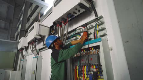 Engineer-Using-Drill-Beside-Control-Box-In-Warehouse