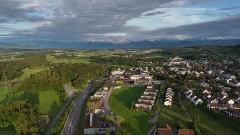 Greifensee,-Suiza,-Con-Exuberante-Vegetación,-Casas-Y-Montañas-Al-Fondo,-Vista-Aérea