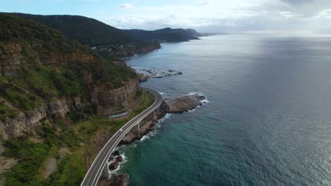 Vídeo-De-Drones-En-4k-Que-Sigue-A-La-Caravana-Que-Circula-Por-Sea-Cliff-Road,-Nueva-Gales-Del-Sur