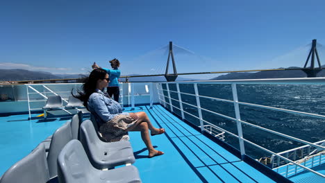 Woman-Enjoying-Ferry-Ride-passing-Rio-Antirrio-Bridge