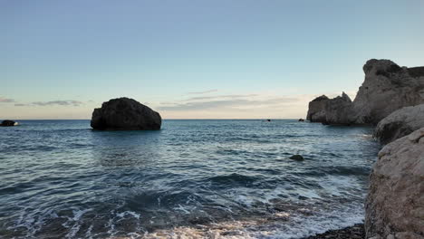 Una-Serena-Vista-Costera-En-Chipre,-Con-Formaciones-Rocosas-En-El-Mar-Y-Una-Superficie-De-Agua-Tranquila,-Capturada-En-Cámara-Lenta---Colinas-De-Afrodita