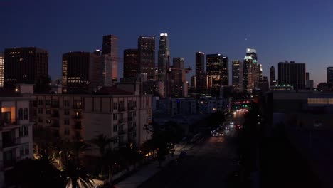 Aerial-low-push-in-shot-of-the-busy-110-Freeway-in-downtown-Los-Angeles-as-night-descends-in-Southern-California