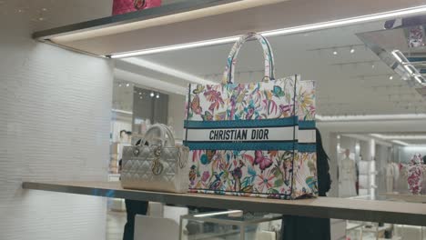 Bolsos-Acolchados-Y-Florales-De-Christian-Dior-Exhibidos-En-Un-Estante-En-Una-Boutique-De-Lujo