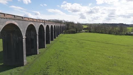 Low-drone-flight-alongside-the-arches-of-Welland-Viaduct-Northamptonshire,-also-known-as-the-Harringworth-and-Seaton-Viaduct-on-sunny-day