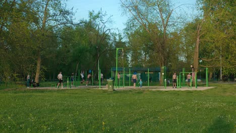 Gente-Haciendo-Ejercicio-En-Un-Gimnasio-Al-Aire-Libre-Rodeado-De-Vegetación-En-El-Lago-Jarun,-Zagreb,-Croacia.