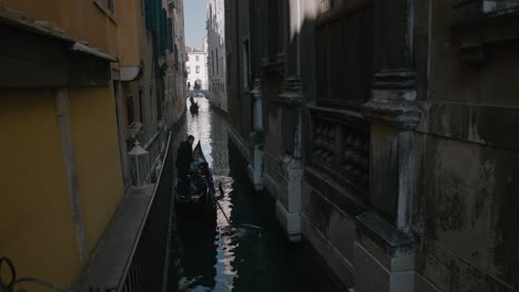 Gondola-ride-through-narrow-canal-in-Venice,-Italy,-featuring-historic-architecture