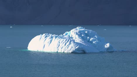 Iceberg-in-Fjord-by-Coastline-on-Greenland-on-Sunny-Summer-Day