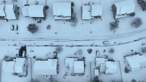 Snowy-aerial-view-of-a-suburban-neighborhood-with-distinct-road-patterns-and-houses,-captured-in-the-USA