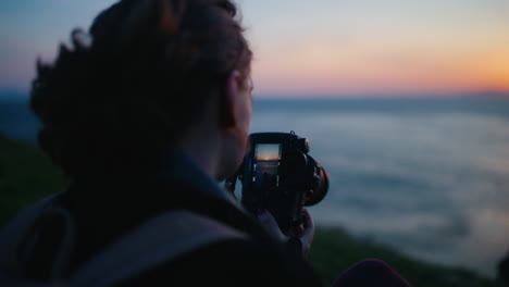 Frau-Fotografiert-Sonnenuntergang-über-Dem-Meer-Und-Schaut-In-Die-Kamera-Zeitlupe