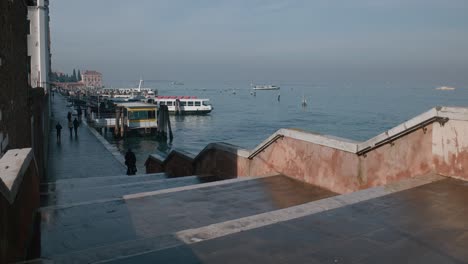 Vista-Panorámica-De-Un-Paseo-Marítimo-Con-Barcos-Atracados-A-Lo-Largo-Del-Canal-En-Venecia,-Italia