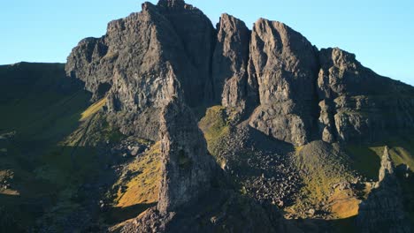 Acantilados-De-Montaña-Desmoronados-Con-Antigua-Aguja-De-Piedra-Volcánica,-El-Anciano-De-Storr-En-Primer-Plano