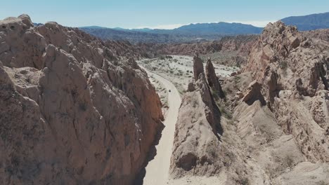 Drone-passing-through-a-canyon-of-rocks-in-the-Salta-Desert,-Argentina