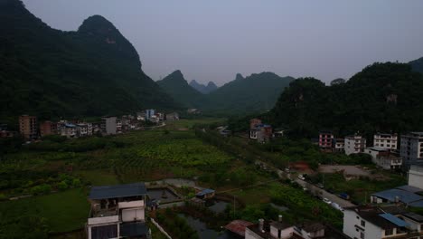 Yangshuo-town-towards-mountains-at-sunrise,-China.-Aerial
