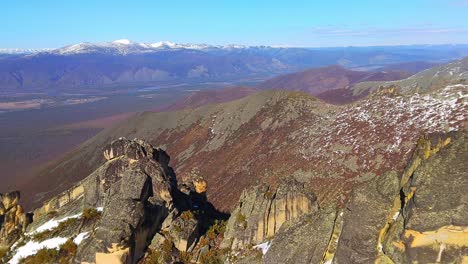 A-snowy-mountain-range-with-snow-covered-ground-and-towering-peaks-in-the-background