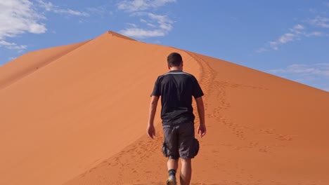 Man-walks-in-a-beautiful-dune-in-Namib-Naukluft-National-Park,-Namibia