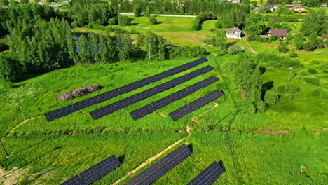 Green-vibrant-field-with-solar-panel-farm,-aerial-orbit-view
